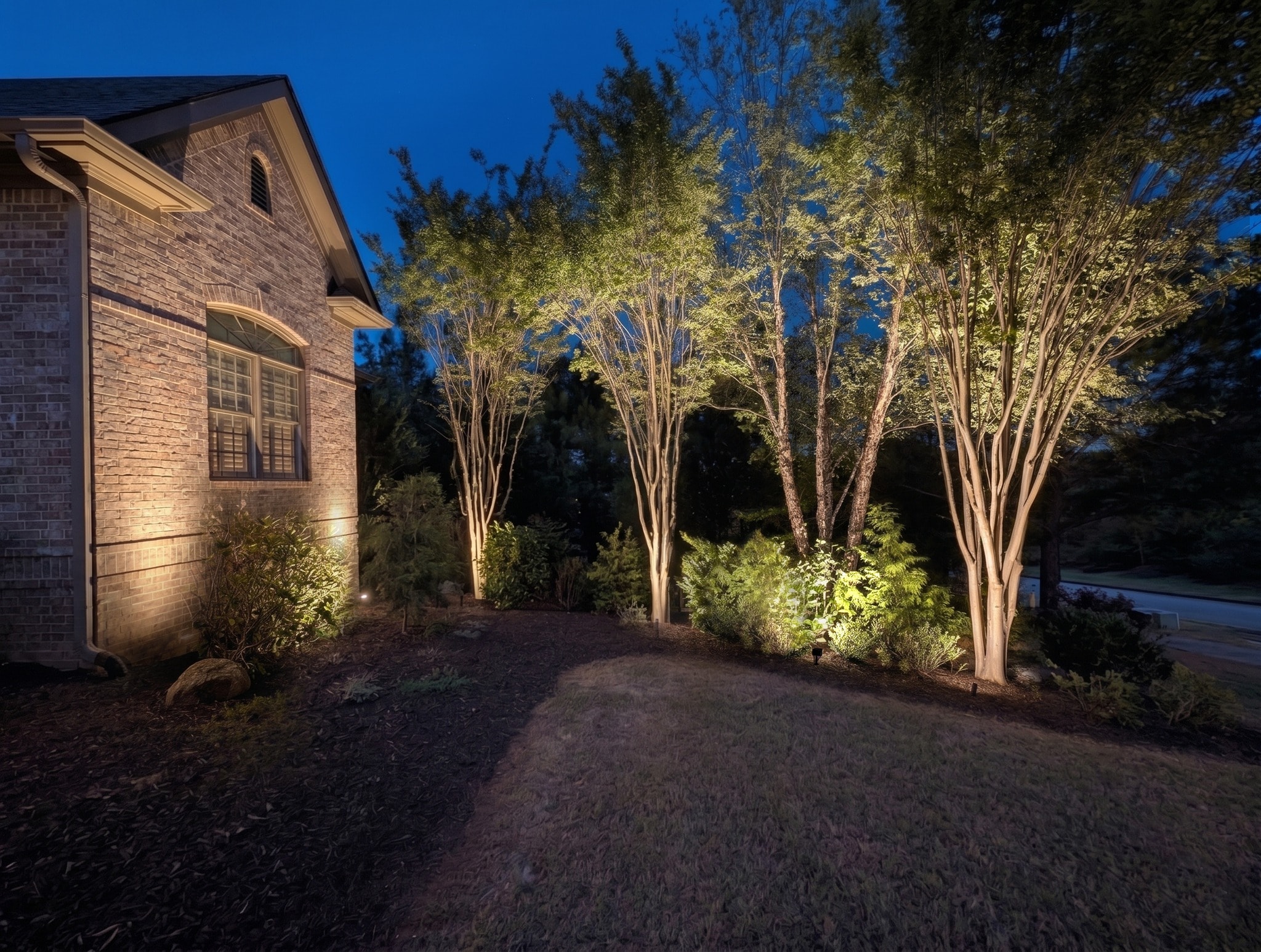 A landscape lighting rendering: a home shown with a recommended lighting design