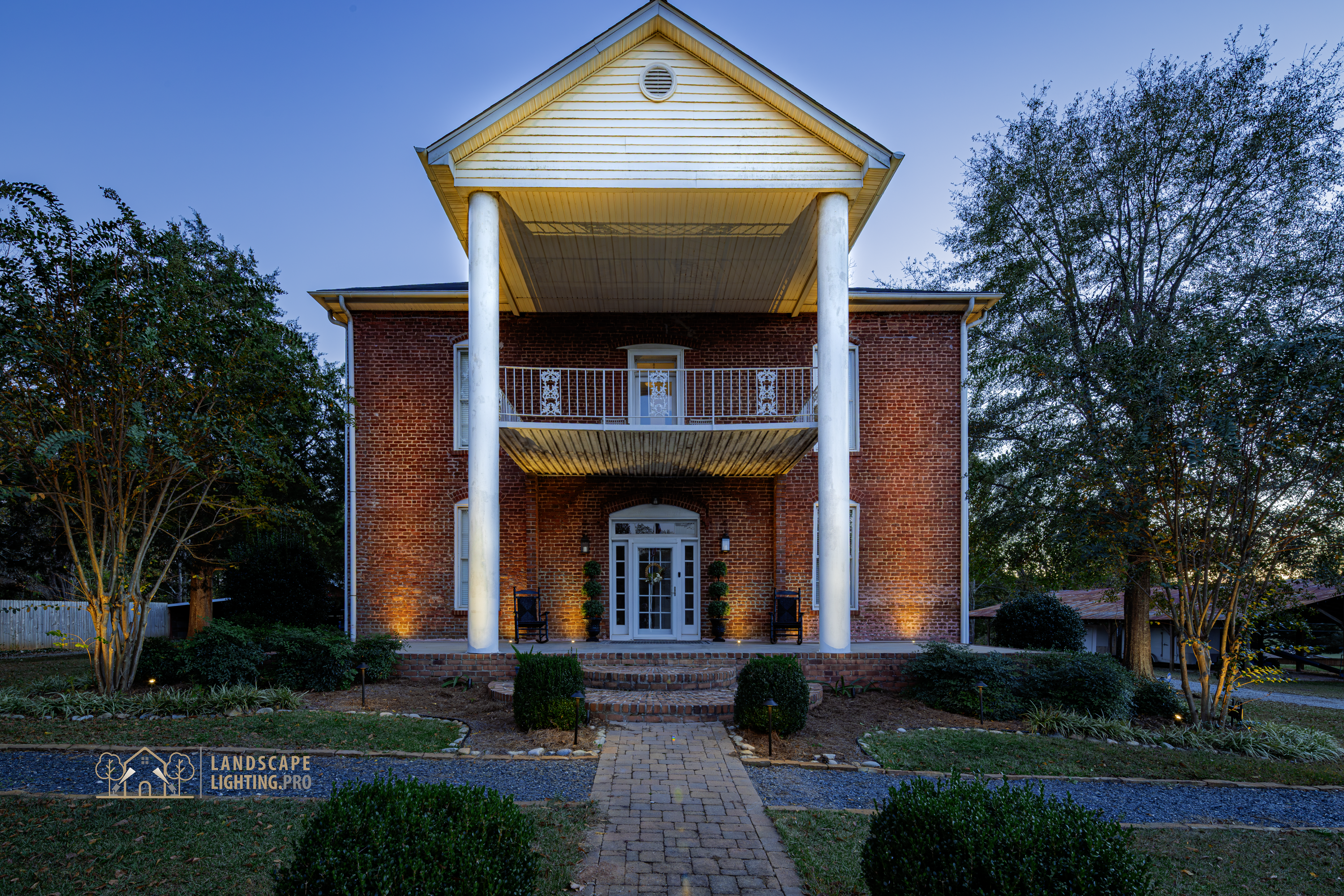 The historic home illuminated at dusk, full view
