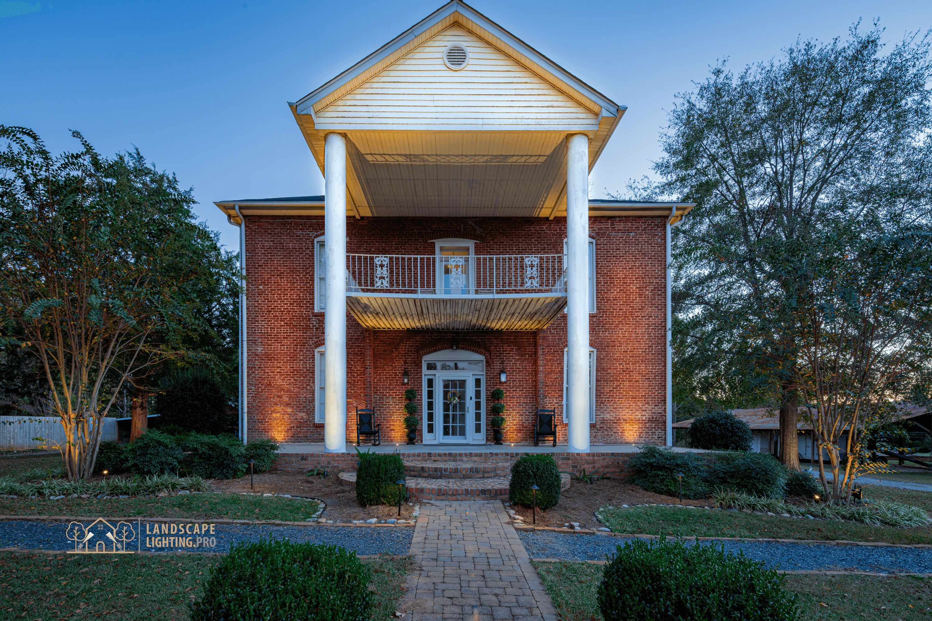 The historic home illuminated at dusk, full view