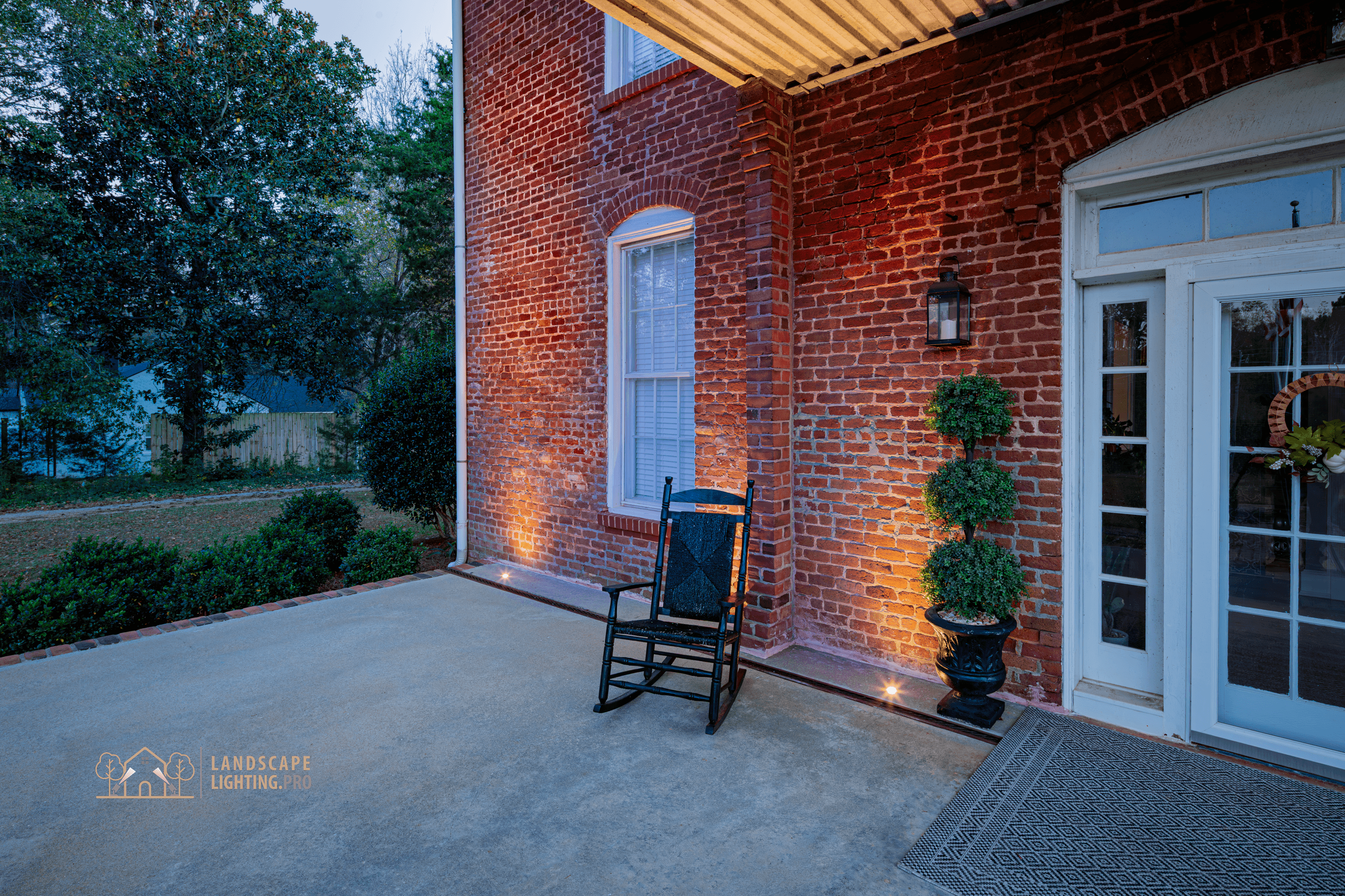 Detail of the 1850 home's lit columns and brick at dusk