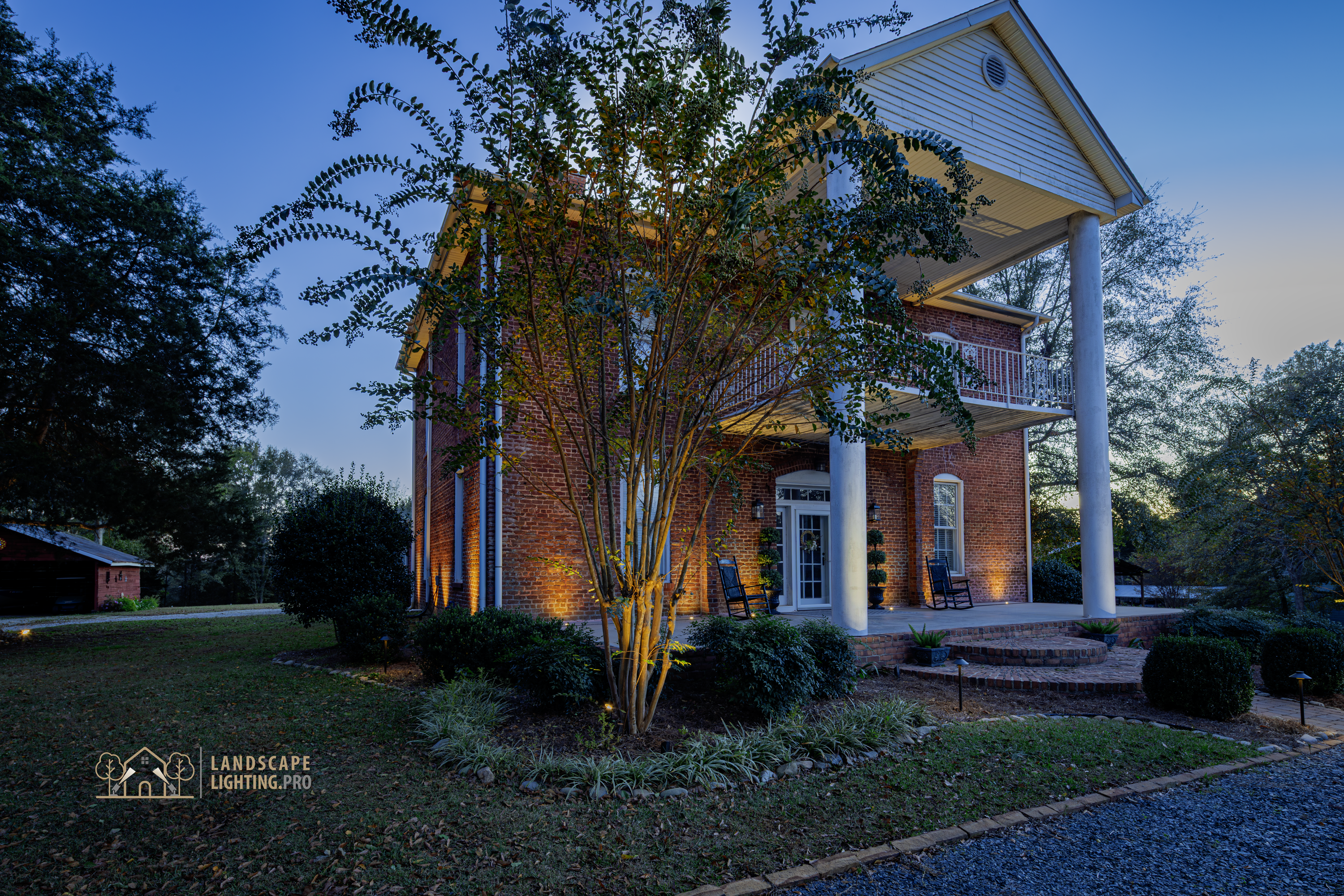A finished view of the historic home's lit landscape and architecture