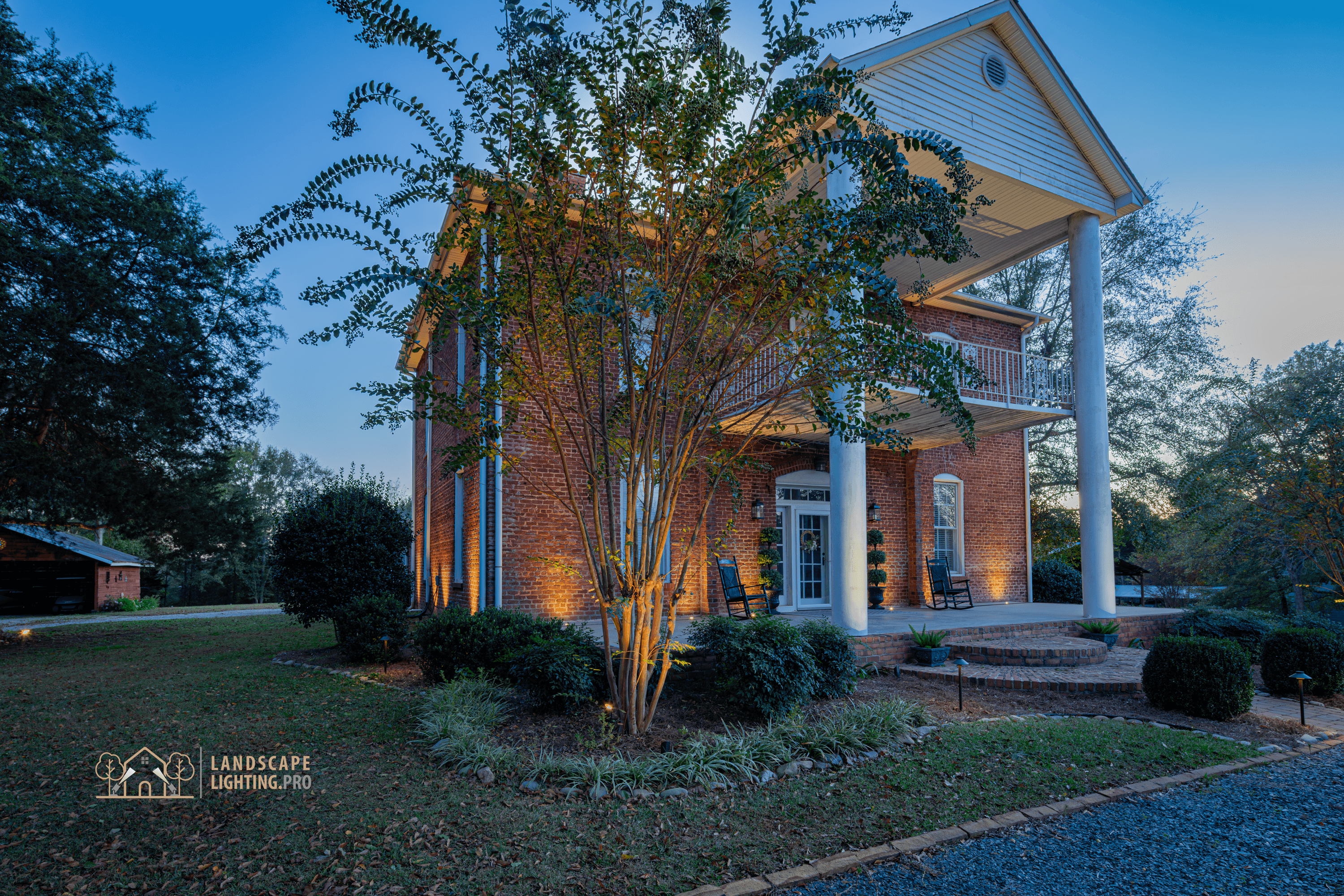A finished view of the historic home's lit landscape and architecture