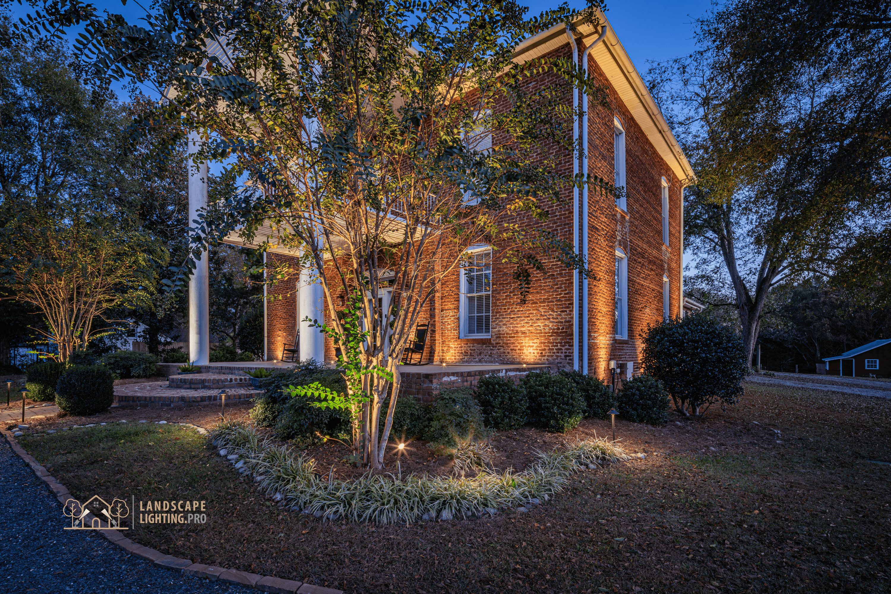 The 1850 home's brick façade illuminated, with columns and frieze in detail