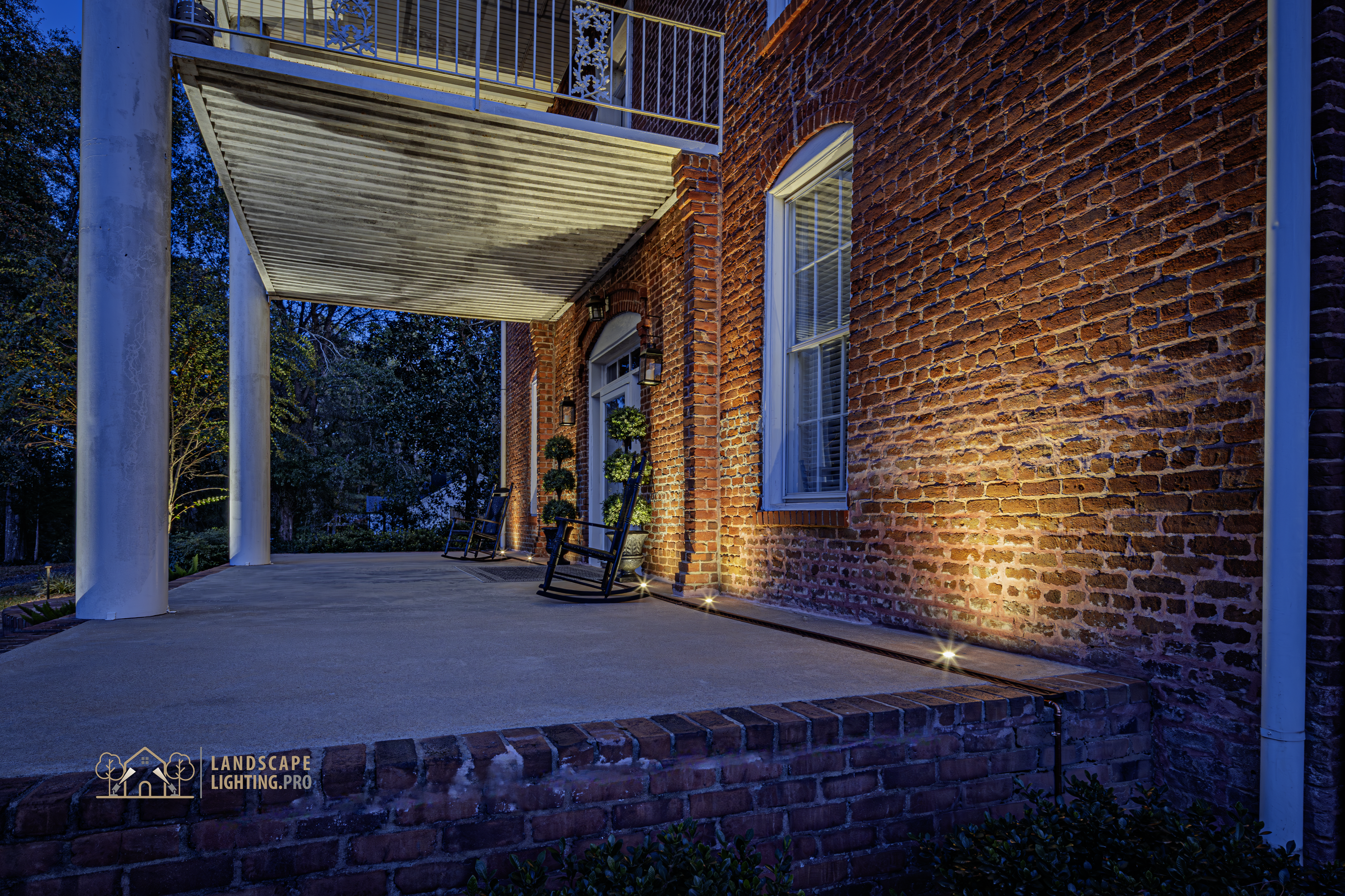 A side angle of the historic home illuminated at dusk