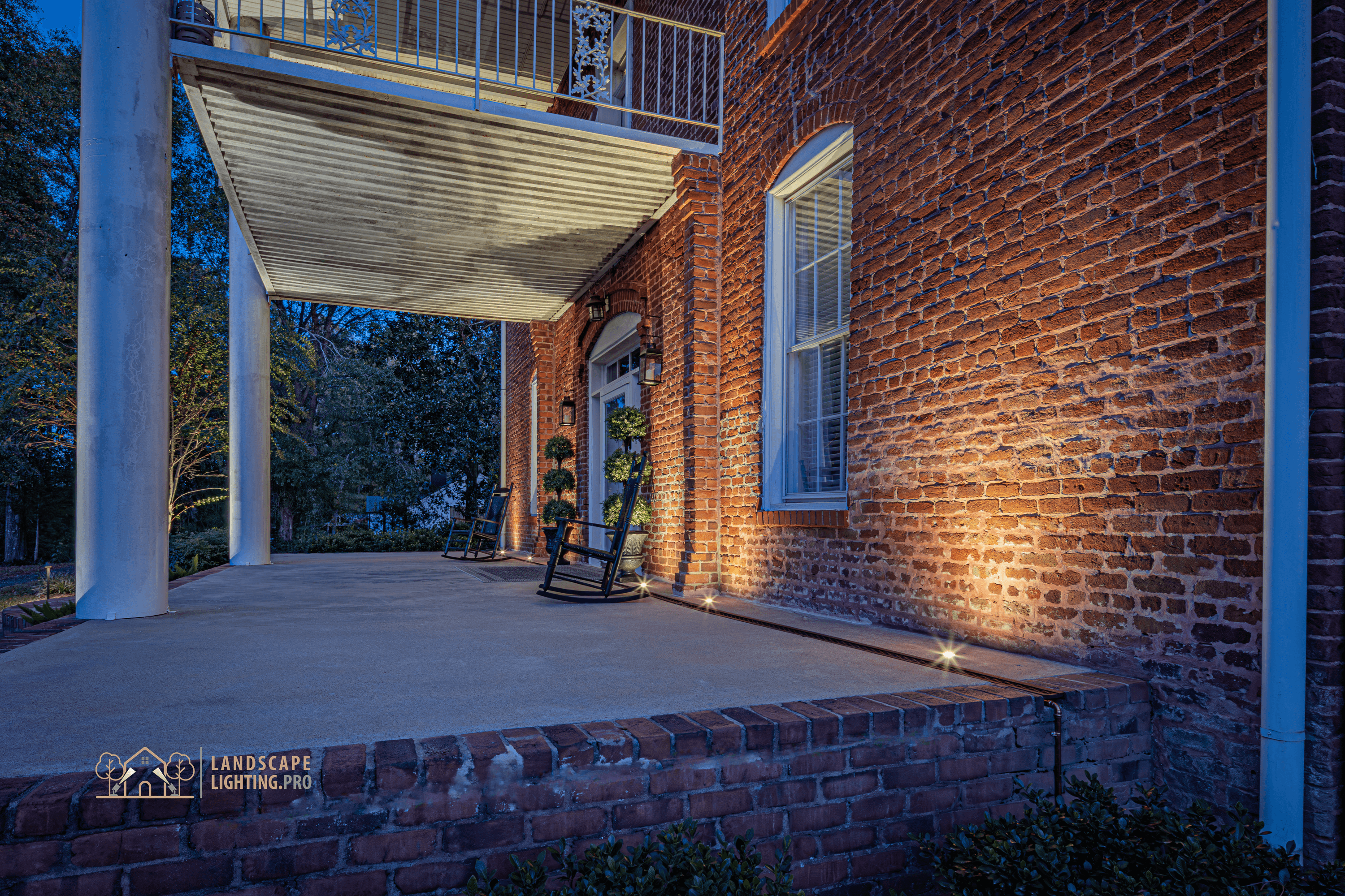 A side angle of the historic home illuminated at dusk