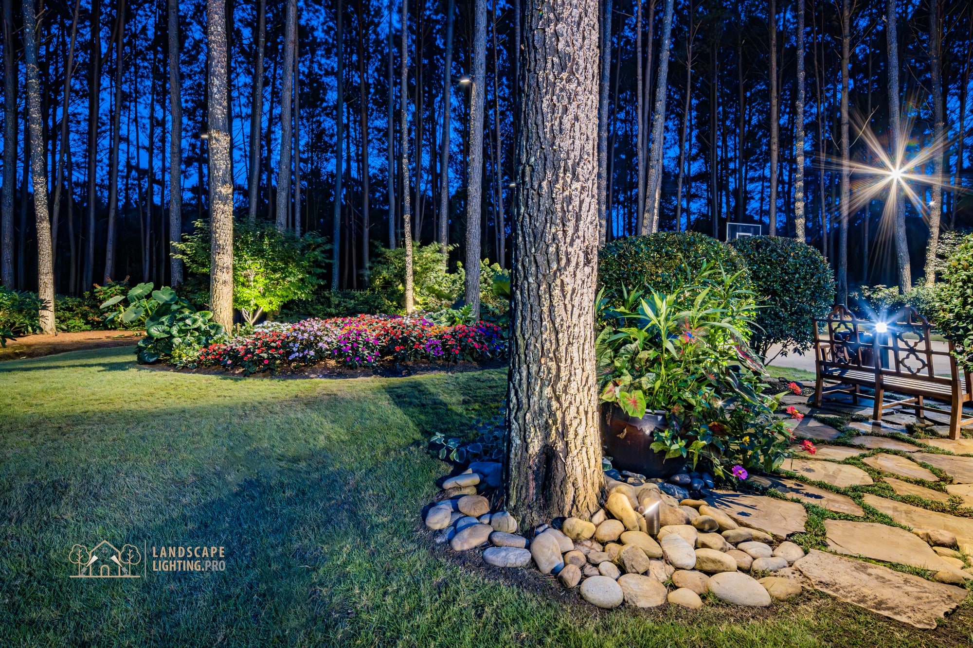 Manicured backyard plantings and lawn lit at dusk on the Newhaven property